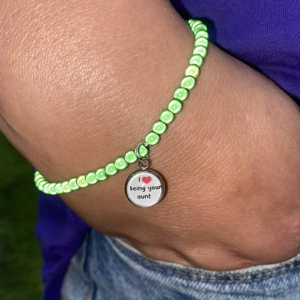 Grnt skinnende armbnd m/anheng - norsk & engelsk tekster